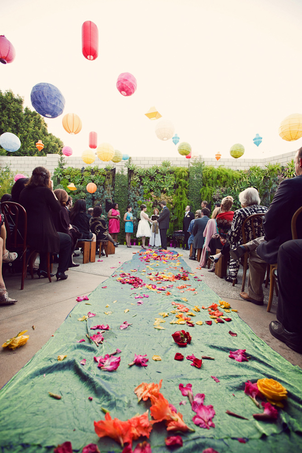 colorful paper lanterns and colorful flower petals decorate an outdoor ceremony site- vintage LA wedding at The Smog Shoppe photo by top Orange County wedding photographer Duke Images
